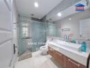 Modern bathroom with glass shower, vanity with sink, and toilet