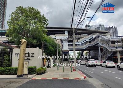 Image showing the front view of a building and surrounding area with visible street and signs