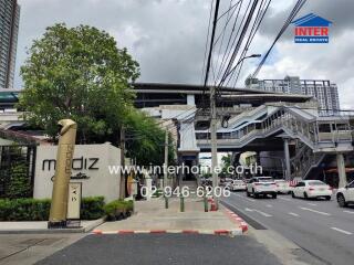 Image showing the front view of a building and surrounding area with visible street and signs