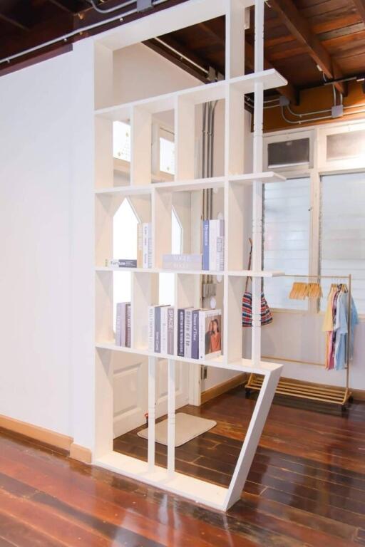 Living area with modern bookshelf and exposed pipes