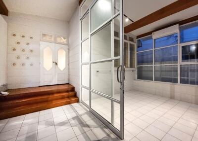 A spacious living area with tiled flooring and glass doors