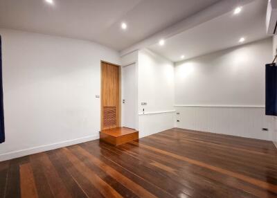 Empty main living area with wooden flooring and recessed lighting