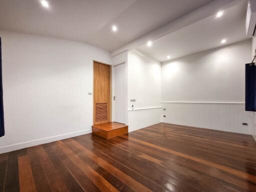 Empty main living area with wooden flooring and recessed lighting