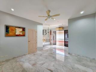 Spacious living area with marble flooring and ceiling fan