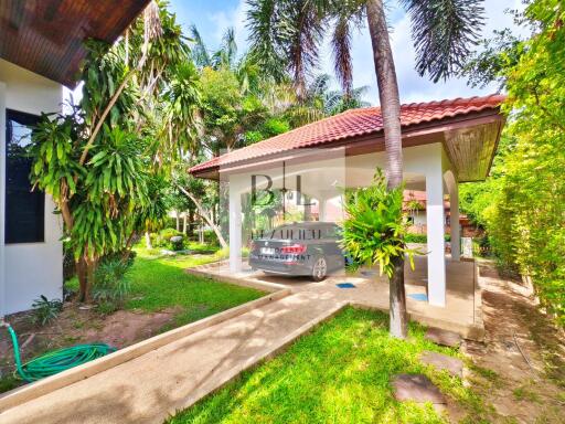 Outdoor view of a property with garden and carport