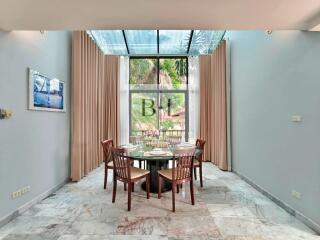 Bright dining room with glass roof and wooden furniture