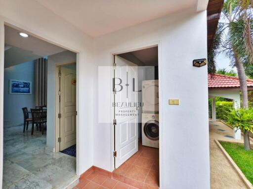 Entrance to laundry area with a view of the kitchen and outdoor space