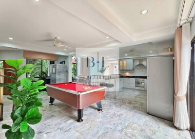 Spacious open-plan living area with billiards table and modern kitchen