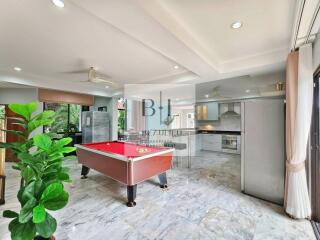 Spacious open-plan living area with billiards table and modern kitchen