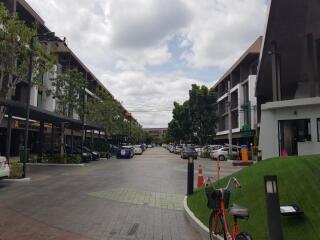 View of residential buildings with parking spaces and greenery