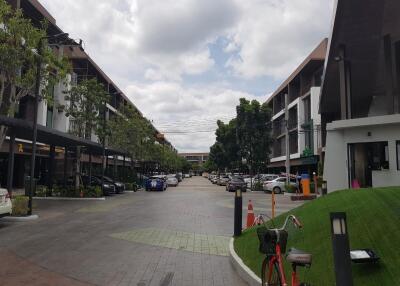 Street view of residential buildings with parked cars