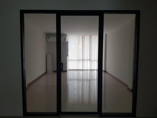 Large empty living room with glass door and vertical blinds