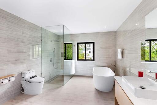 Modern bathroom with bathtub, shower, toilet, and double vanity