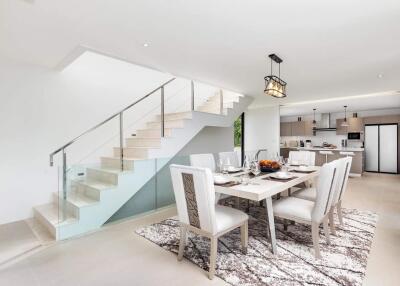 Bright dining area with modern kitchen and staircase