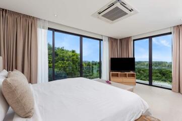 Modern bedroom with large windows and outdoor views