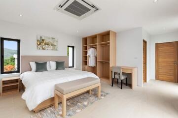 Spacious and modern bedroom with bed, wardrobe, and desk