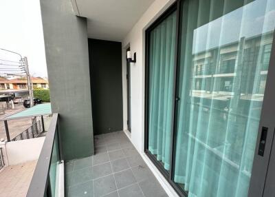 A small balcony with sliding glass doors covered by curtains