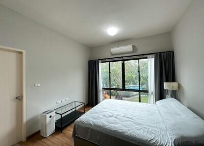 Bedroom with large window, bed, air conditioner, and modern furnishings