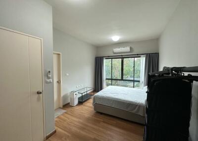 Modern bedroom with a large window and minimalistic furnishings