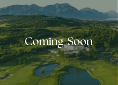 Coming Soon - Scenic view of a golf course with mountains in the background