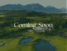 Coming Soon - Scenic view of a golf course with mountains in the background