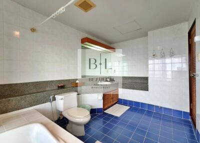 Spacious and modern bathroom with blue tile floor and white walls