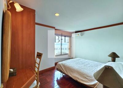 Spacious bedroom with wooden furniture and a neatly made bed