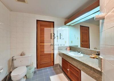 Modern bathroom with wooden cabinetry and large mirror