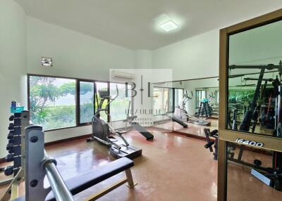 Home gym with various exercise equipment and large windows