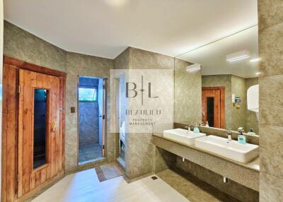 Modern bathroom with double sinks and wooden sauna