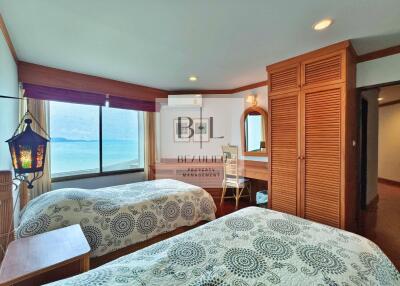 Bedroom with twin beds, ocean view, and wooden furniture