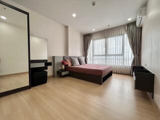 Modern bedroom with wooden flooring, large window, and contemporary furnishings