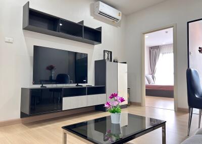 Modern living room with mounted TV and adjacent bedroom