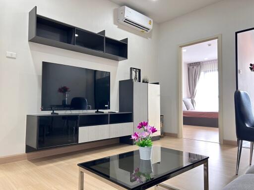 Modern living room with mounted TV and adjacent bedroom