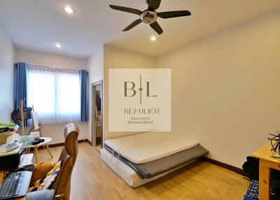 Spacious bedroom with natural light and ceiling fan