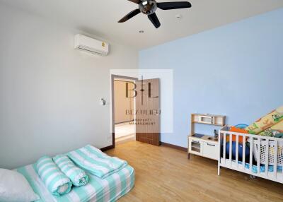 Bright and airy bedroom with a baby crib and low bed