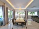 Modern dining room with large table, chandelier, and natural lighting