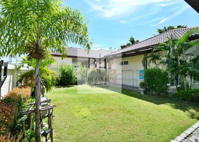 Spacious backyard garden with lush greenery and palm trees