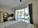 Spacious bedroom with sliding glass doors opening to a pool view