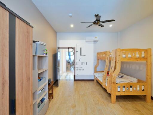 Bedroom with bunk beds, wardrobe, ceiling fan, and wooden floor