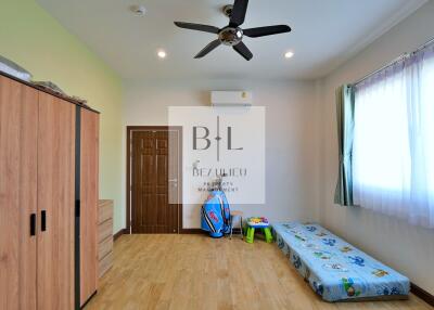 Bedroom with wooden wardrobe, air conditioning, and single bed