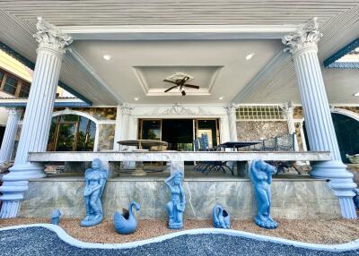 Front entrance of a house with columns and statues