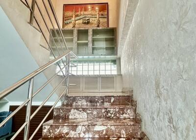 Marble staircase with chandelier and artwork