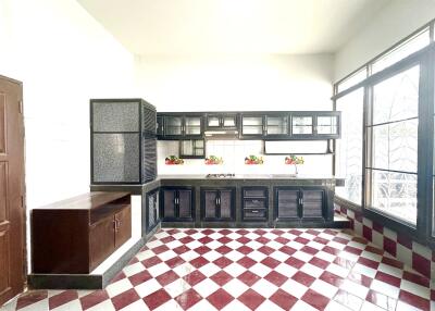 Spacious kitchen with large windows and checkered flooring