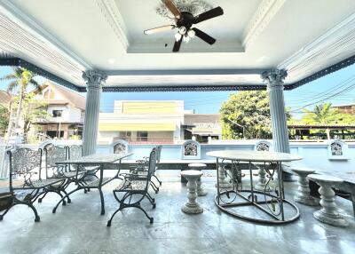 Spacious outdoor patio with elegant columns and seating area