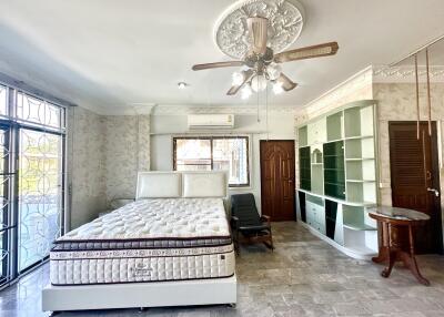 Spacious bedroom with bed, ceiling fan, and built-in storage