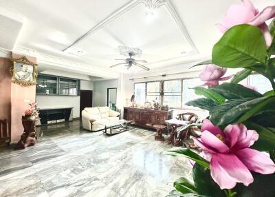 spacious living room with marble flooring and ornate ceiling decor