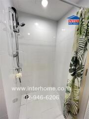 Modern tiled shower area with a tropical-themed shower curtain