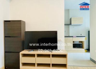 Modern living area with television and adjacent kitchen