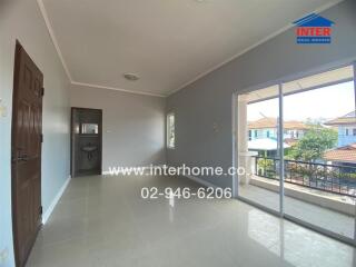 Spacious living room with large windows and balcony access